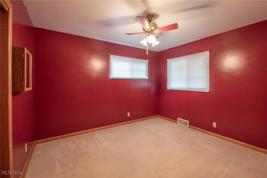 Empty room with carpet and a ceiling fan
