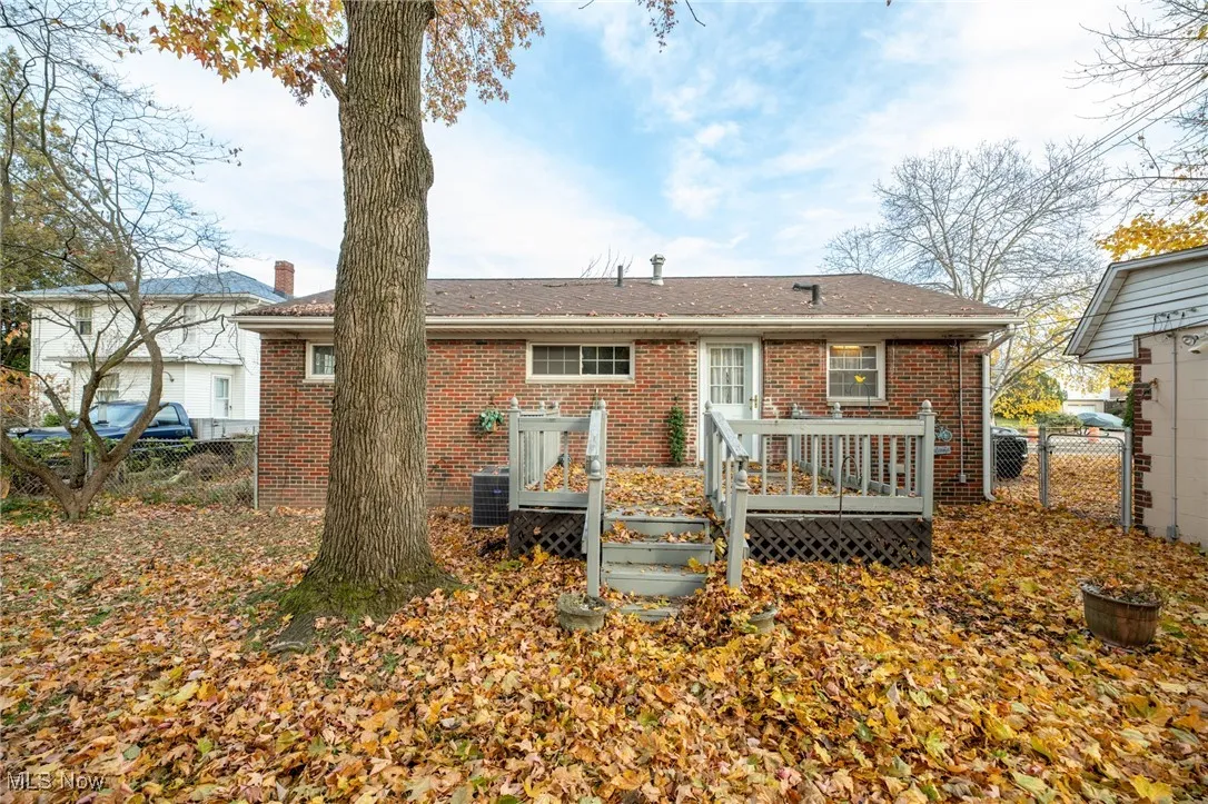 Back of house featuring brick siding and a deck
