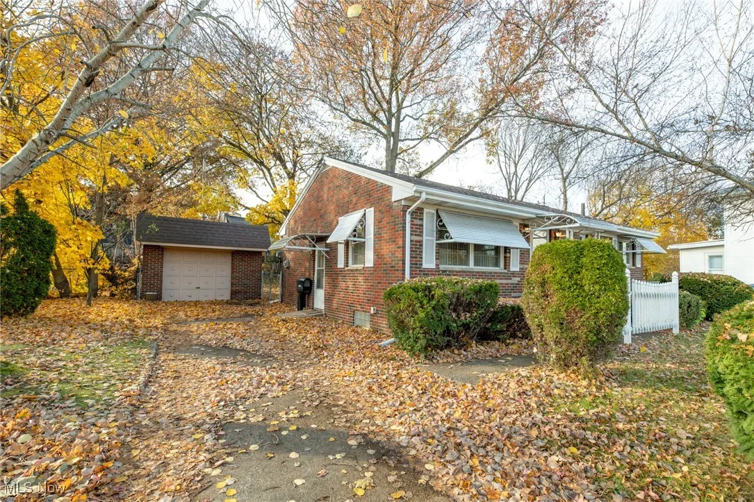 View of home's exterior with brick siding, an outdoor structure, and a garage