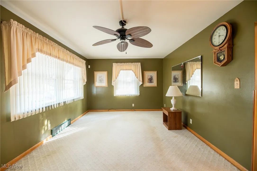 Family room with a ceiling fan and carpet