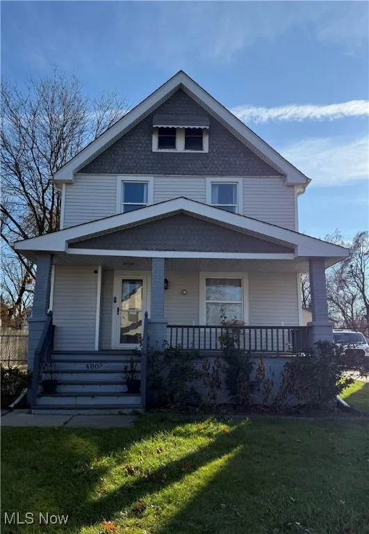 Traditional style home with covered porch and a front lawn