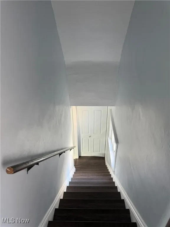 Stairs with wood finished floors and baseboards