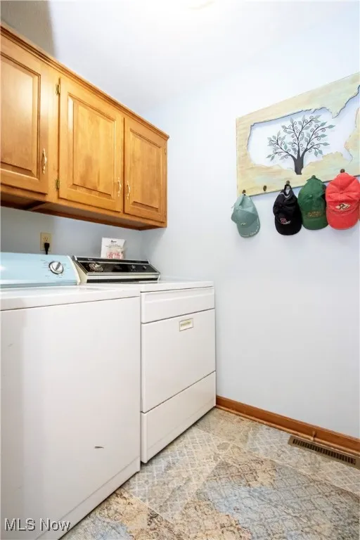 Laundry room with cabinet space and washer and clothes dryer