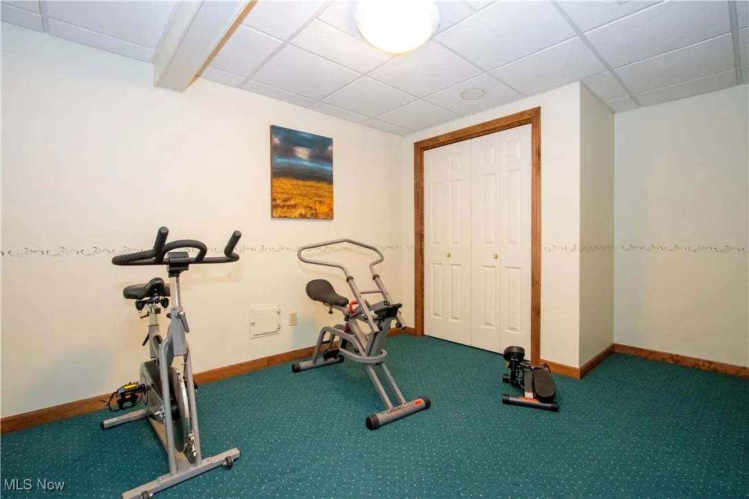 Exercise room with carpet floors and a drop ceiling