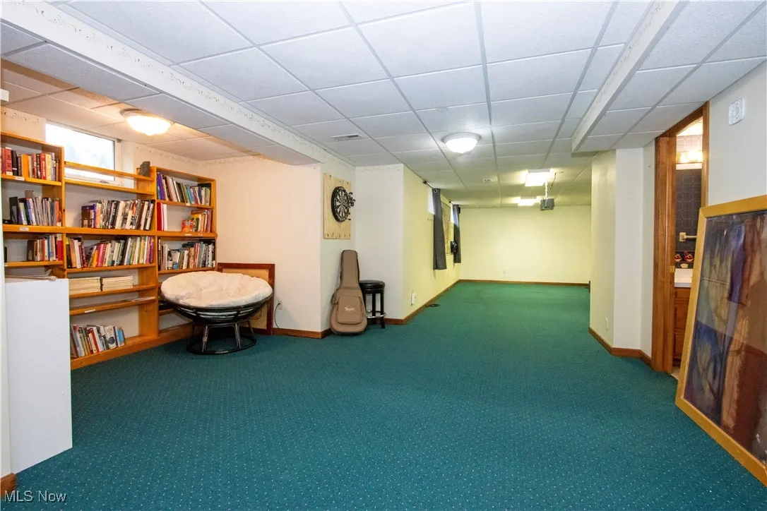 Living area with carpet floors and a drop ceiling