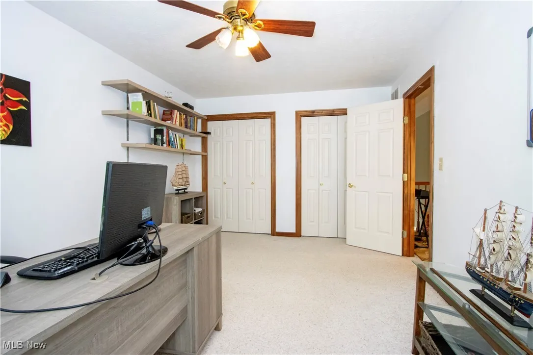 Office with ceiling fan and light carpet