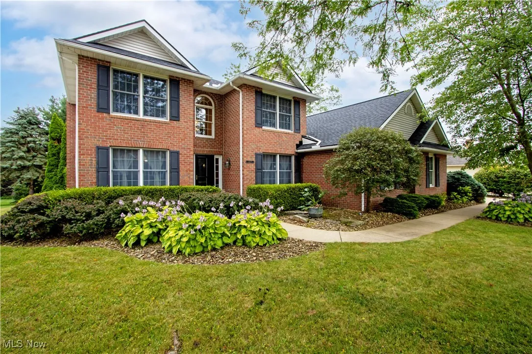 View of front of home with brick siding and a front yard