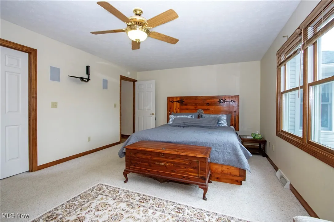 Carpeted bedroom with baseboards and a ceiling fan
