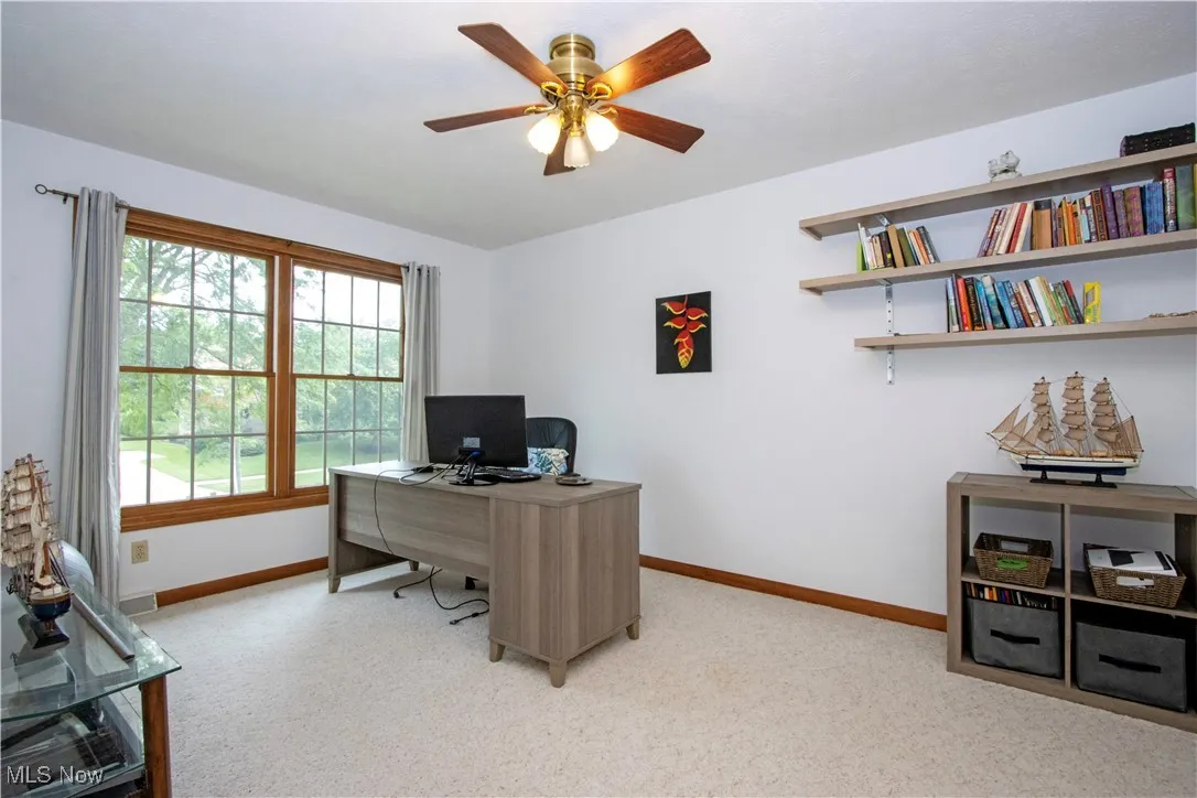 Office with light colored carpet and ceiling fan
