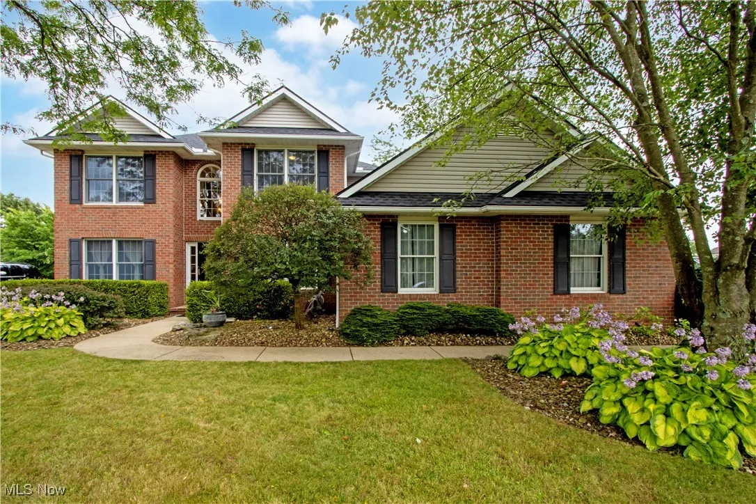 View of front facade featuring a front lawn and brick siding