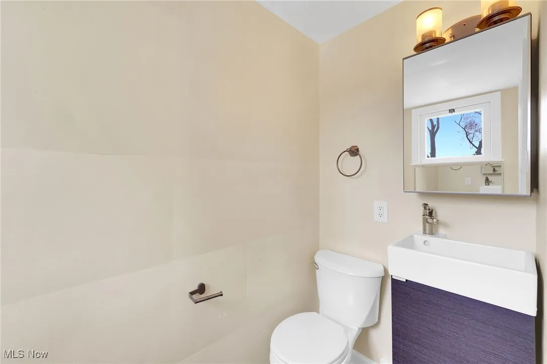 Half bathroom with vanity and toilet