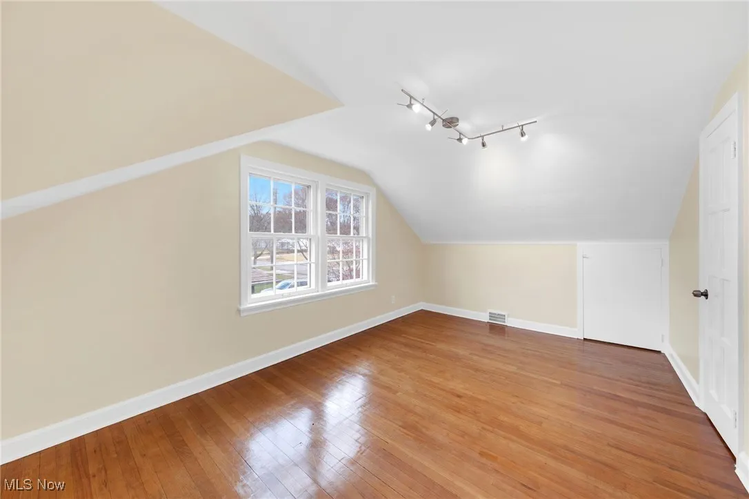 Additional living space featuring light wood-type flooring and lofted ceiling