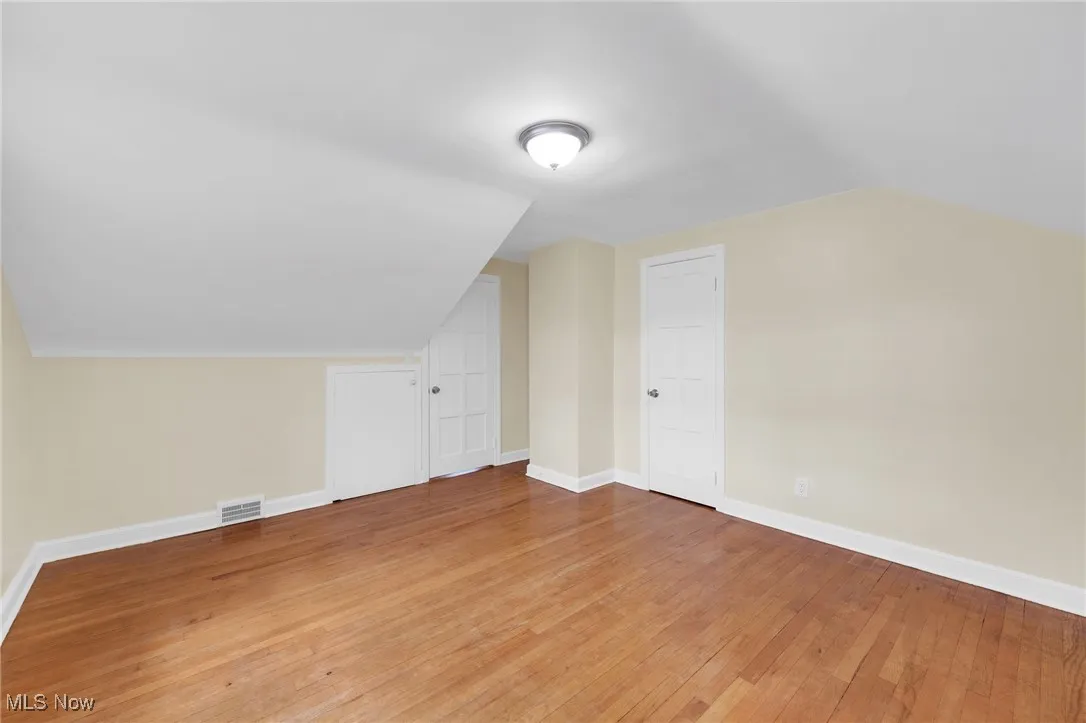 Additional living space with vaulted ceiling and light wood-type flooring
