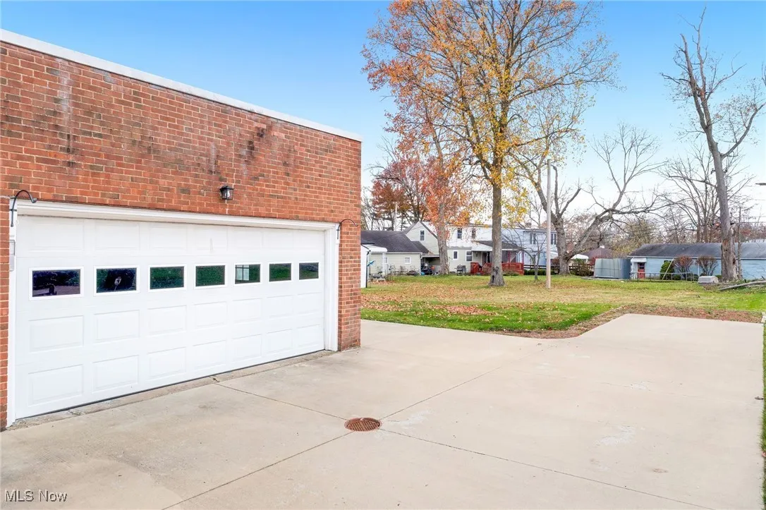 Garage featuring concrete driveway and a residential view