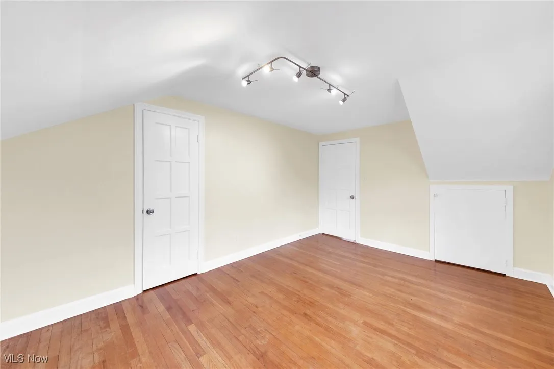 Additional living space featuring vaulted ceiling and light wood-type flooring