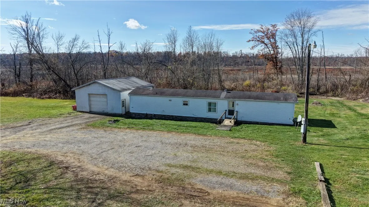 View of outbuilding with dirt driveway and a garage