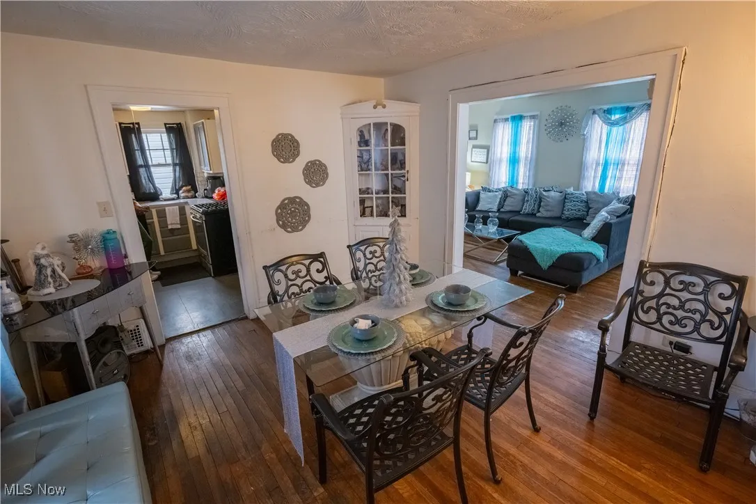 Dining space with hardwood / wood-style flooring and a textured ceiling