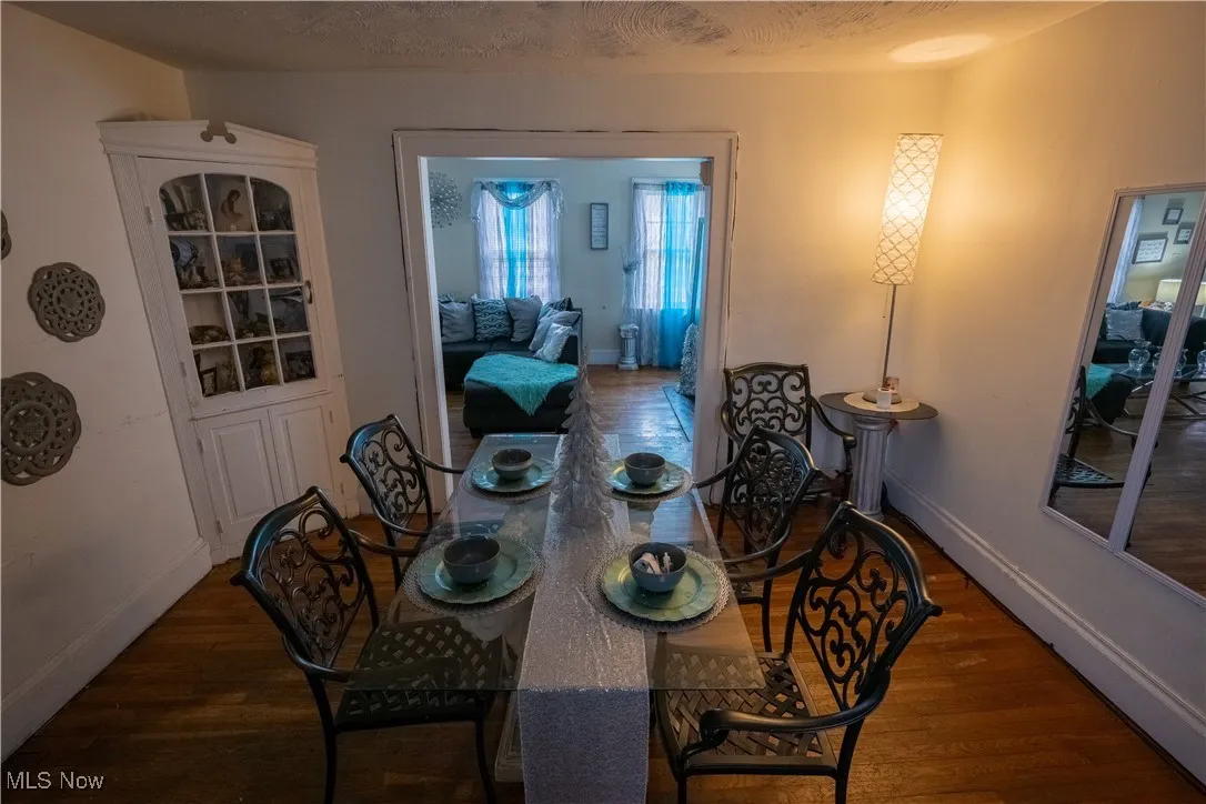Dining area with dark wood-style flooring and a textured ceiling