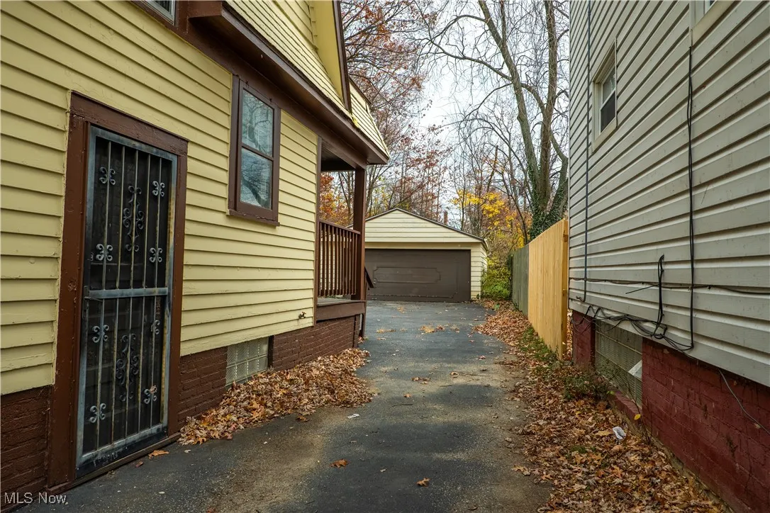 View of property exterior featuring an outdoor structure and a detached garage