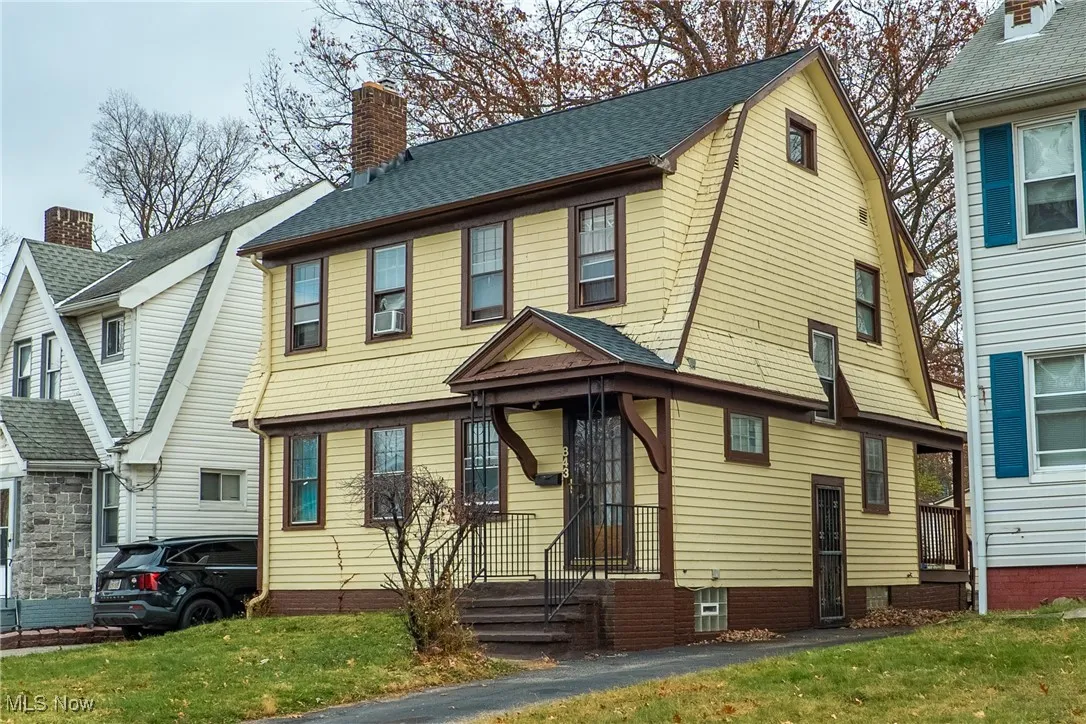 View of front of property featuring roof with shingles, a chimney, a gambrel roof, and a front yard