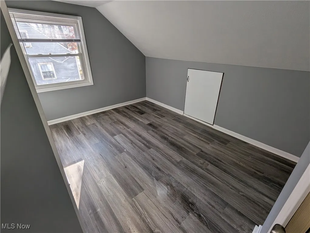 Upper level Bedroom with wood finished floors and lofted ceiling