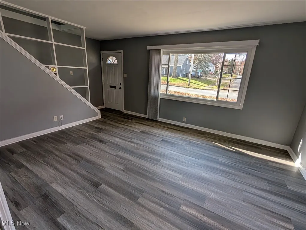 Foyer entrance with wood finished floors and baseboards