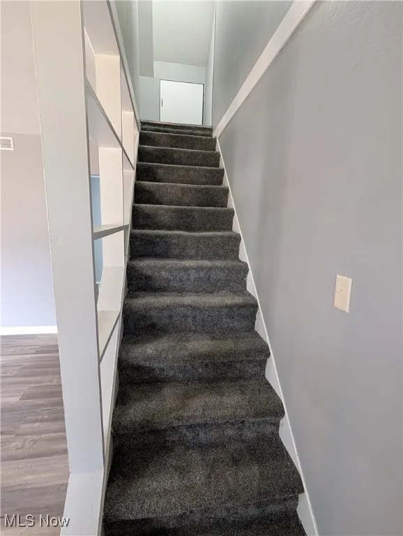 Stairway featuring wood finished floors and baseboards