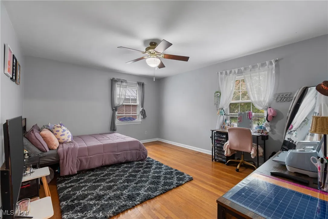 Living room with a textured ceiling, wood finished floors, arched walkways, and ceiling fan