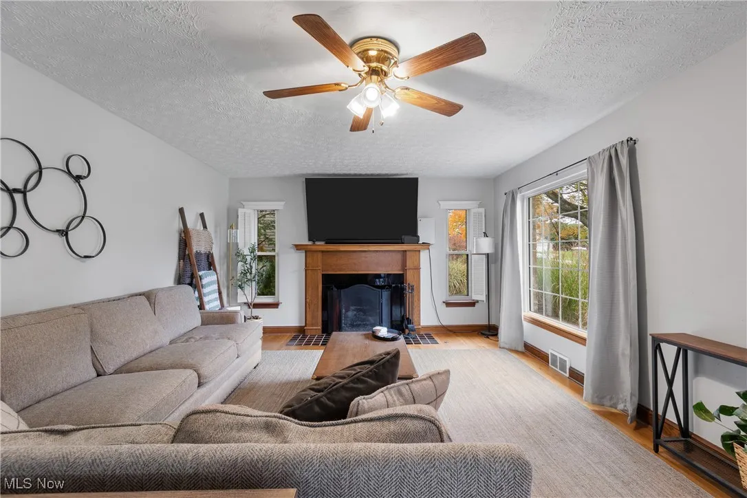 Bedroom featuring light hardwood  finished floors, multiple windows, a ceiling fan, natural light