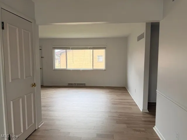 Empty room featuring light wood finished floors and baseboards