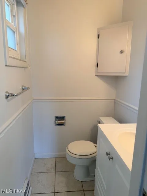 Half bath featuring vanity and light tile patterned floors