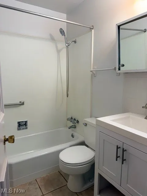 Bathroom with vanity, shower / bath combination, and light tile patterned flooring