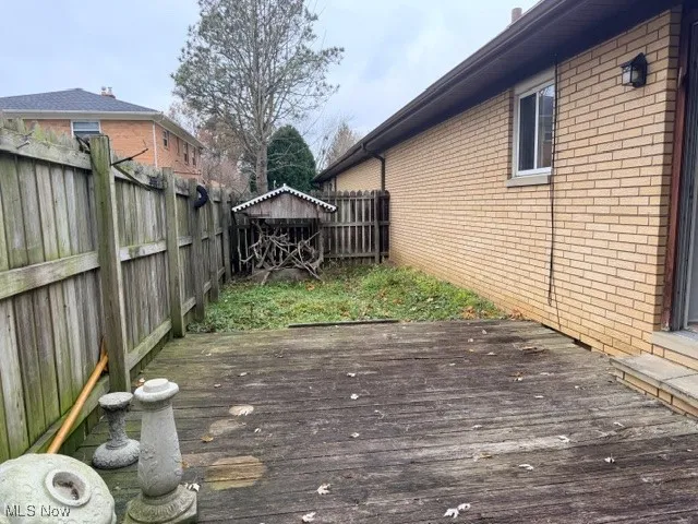 Wooden deck with a fenced backyard