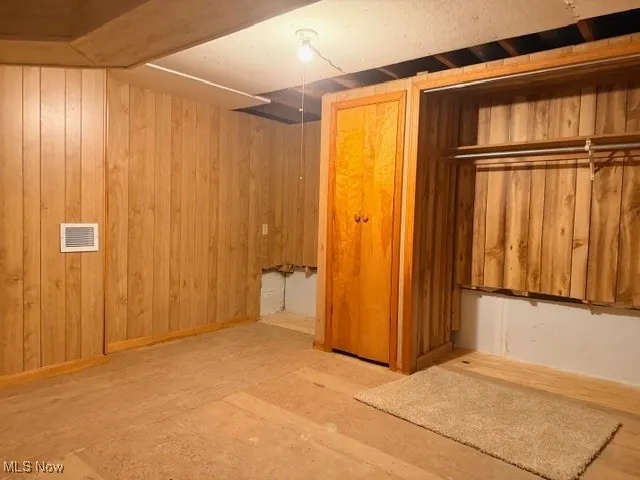 Finished basement featuring wooden walls