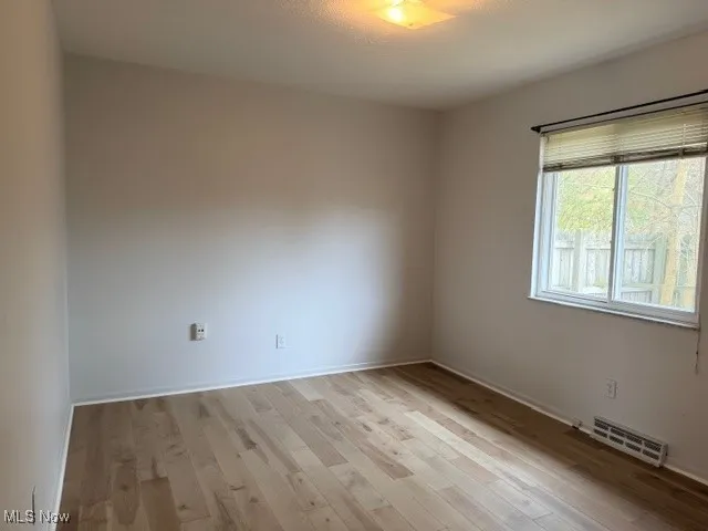 Spare room with light wood-style floors and baseboards