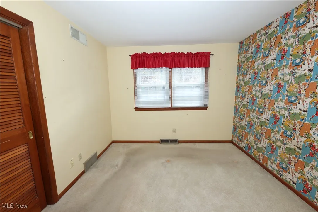 Unfurnished bedroom with carpet flooring and baseboards