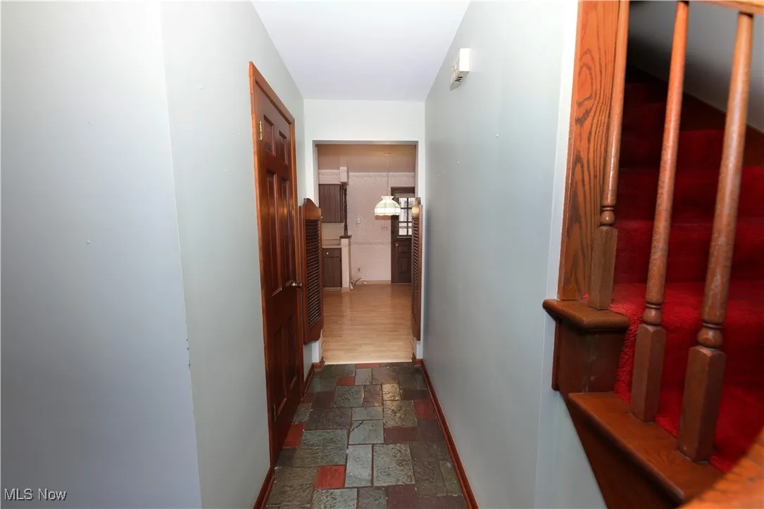 Hallway with stone tile floors and baseboards