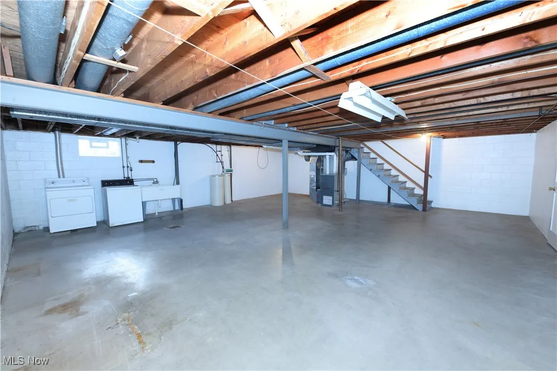 Below grade area with stairs, washing machine and dryer, and heating unit