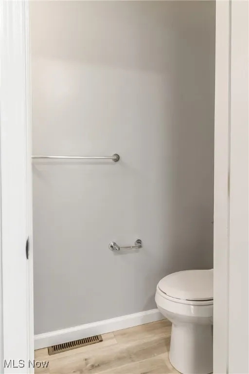 Bathroom with light wood finished floors and toilet