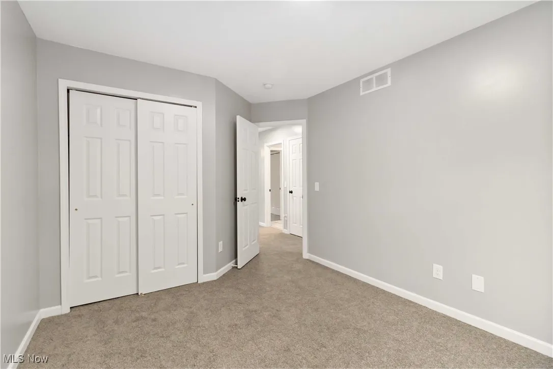 Unfurnished bedroom featuring light colored carpet and a closet