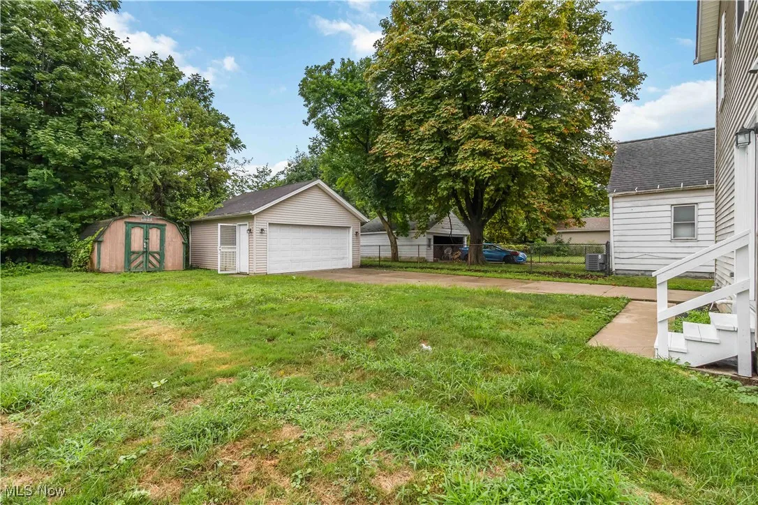 View of yard with a detached garage and a shed