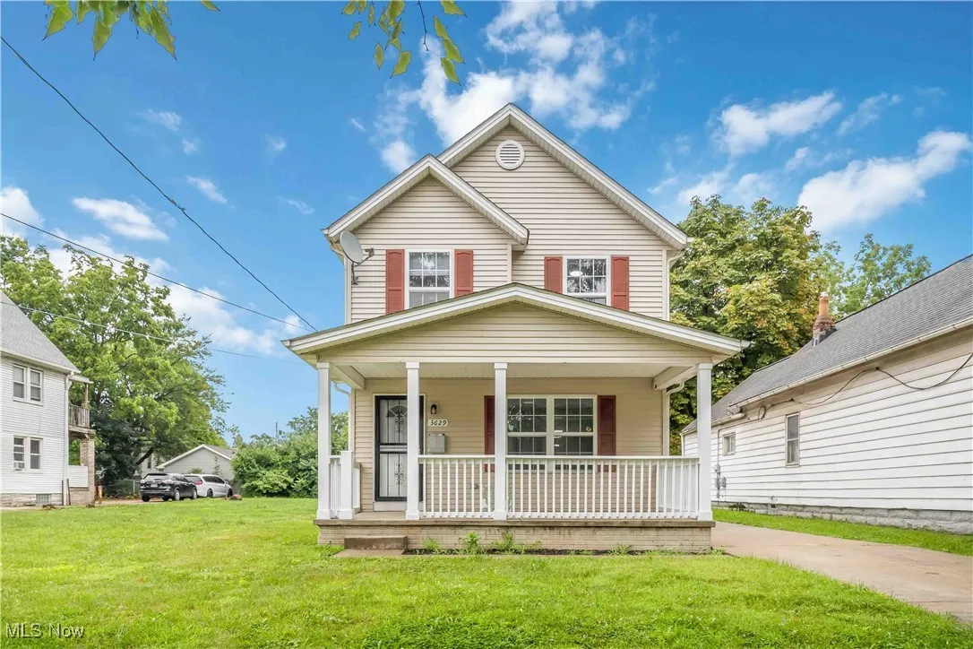 View of front of property with covered porch and a front lawn