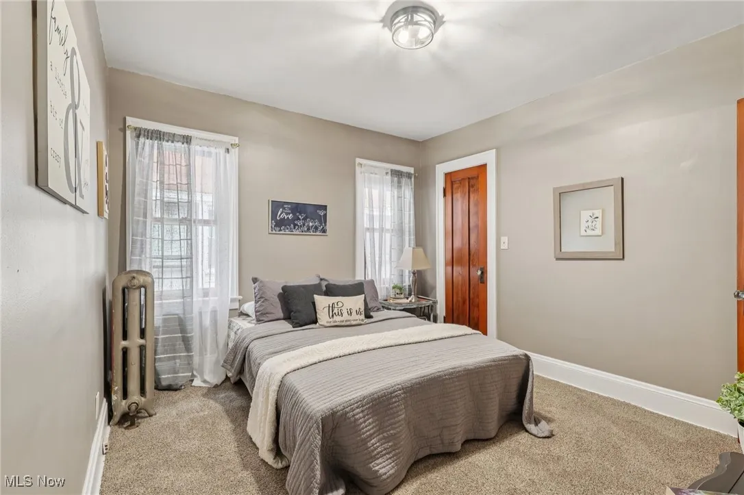 Bedroom featuring radiator heating unit and carpet flooring