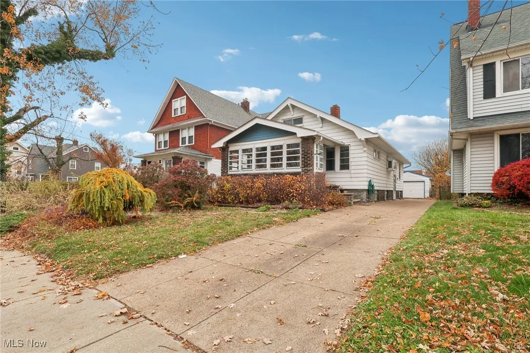 View of front of home with an outdoor structure, a front lawn, and a chimney