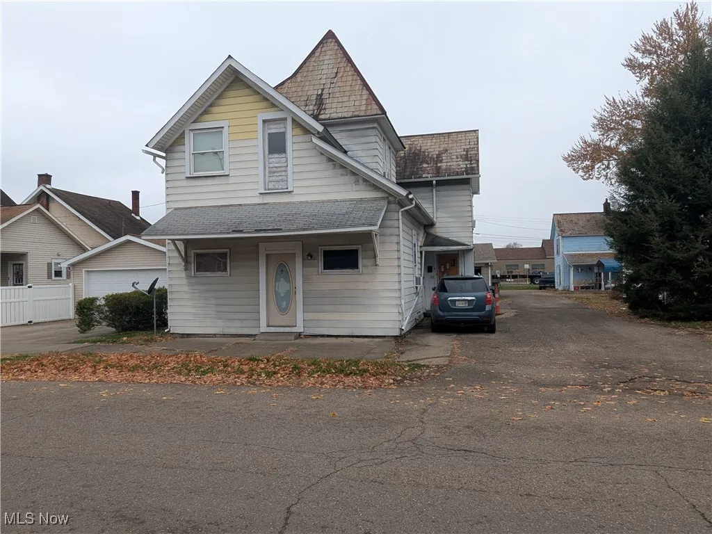 View of front of home featuring roof with mainly slate roof and shingles on lower levels