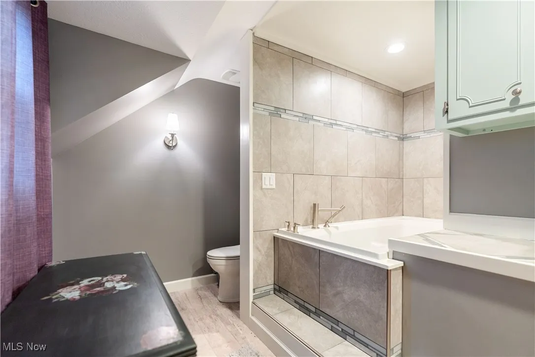 The master bath has a soaking tub with pretty tile walls.