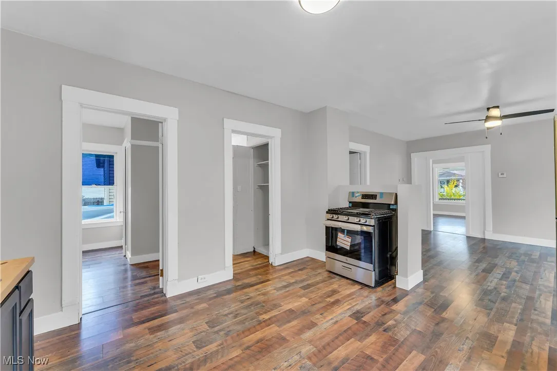 Kitchen featuring stainless steel gas range, dark wood-type flooring, a ceiling fan, and butcher block counters