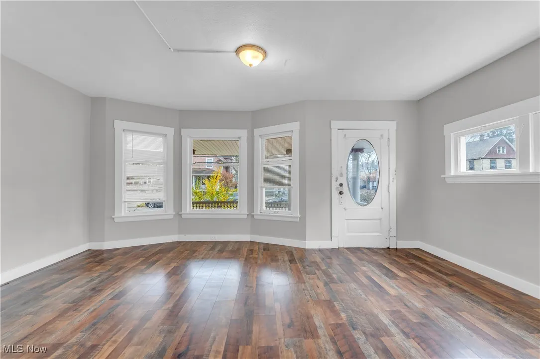 Foyer with dark wood finished floors and baseboards