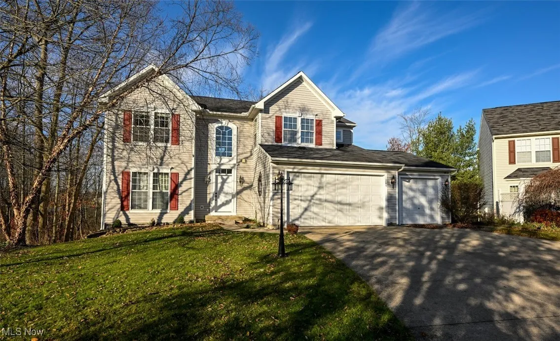 Traditional-style home featuring concrete driveway and a front lawn