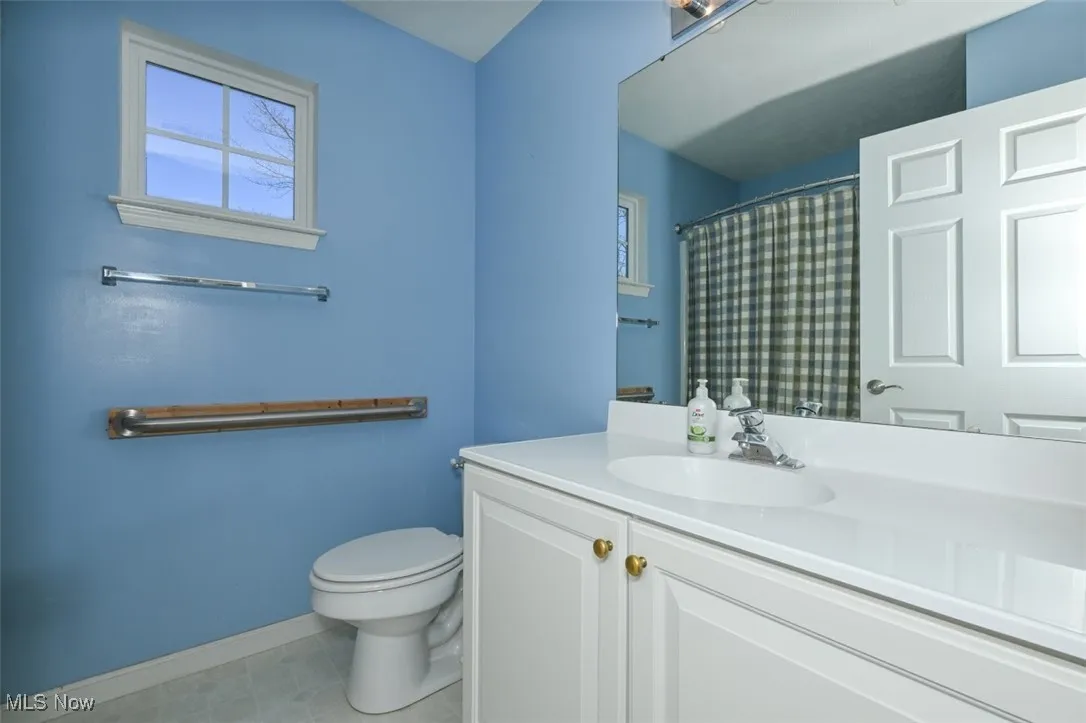 2nd floor hall bathroom featuring a shower tub combo with curtain, vanity, and light vinly flooring